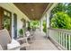 Relaxing front porch featuring rocking chairs, a ceiling fan, wood floors and trim, and views of a lush green lawn at 505 Junction Pt, Roswell, GA 30075