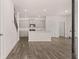 View of the kitchen and living room with gray cabinets, stainless steel appliances, and hardwood floors at 564 Silver Moon Dr, Loganville, GA 30052