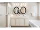 Bathroom featuring double sinks with oval mirrors, a soaking tub, and a walk-in shower at 7863 Kiverton Pl, Atlanta, GA 30350