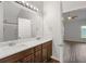 Bathroom with double sink vanity, large mirror and modern fixtures plus view to bedroom at 80 Pulaski Pl, Jonesboro, GA 30238