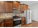 Bright kitchen with stainless steel appliances, dark wood cabinets, and granite countertops at 80 Pulaski Pl, Jonesboro, GA 30238