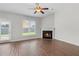 Spacious living room features a cozy fireplace, ceiling fan and bright view to the yard at 80 Pulaski Pl, Jonesboro, GA 30238