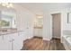Bright bathroom featuring double vanity with granite counters and wood-look flooring at 11851 Rizvan Pl, Covington, GA 30014