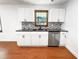 Updated kitchen with white cabinetry, mosaic backsplash and stainless dishwasher at 144 Morning Creek Rd, Jonesboro, GA 30238