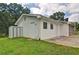 Back exterior featuring white vinyl siding and lush green backyard with small storage shed at 24 Echo Ridge Dr, Powder Springs, GA 30127