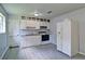 Cozy kitchen includes white cabinets, appliances, and light grey laminate flooring at 24 Echo Ridge Dr, Powder Springs, GA 30127