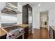 Close up of a modern kitchen featuring stainless steel range hood, granite countertop, and dark wood cabinetry at 3325 Piedmont Ne Rd # 1708, Atlanta, GA 30305