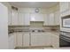 Classic kitchen with white appliances and cabinets, plus a wall mounted clock above the stovetop at 3530 Piedmont Ne Rd # K8, Atlanta, GA 30305