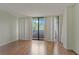 Bright living room featuring sleek hardwood floors, sliding glass doors to a balcony, and fresh white walls at 3530 Piedmont Ne Rd # K8, Atlanta, GA 30305
