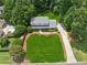 Aerial view showcases the property's expansive manicured lawn, mature trees, and long driveway at 4984 Wickford Way, Atlanta, GA 30338