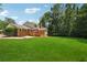 The backyard of this brick home features a large grassy area and mature trees at 4984 Wickford Way, Atlanta, GA 30338