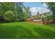 Large manicured backyard with a deck, mature trees, and lush green grass at 4984 Wickford Way, Atlanta, GA 30338