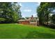 The backyard offers green grass, mature trees, and a sunroom that exits onto a wood deck at 4984 Wickford Way, Atlanta, GA 30338