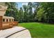 Spacious backyard with lush lawn, a deck, an outdoor patio, and mature trees at 4984 Wickford Way, Atlanta, GA 30338