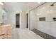 Bright bathroom featuring granite counters and walk-in shower with marble surround, glass doors and hex tile flooring at 4984 Wickford Way, Atlanta, GA 30338
