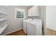 The laundry room has a side-by-side washer and dryer, storage cabinets, and natural light at 4984 Wickford Way, Atlanta, GA 30338