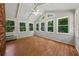 Bright sunroom with hardwood floors, vaulted ceilings, large windows, and a brick accent wall at 4984 Wickford Way, Atlanta, GA 30338