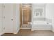 Modern bathroom features glass shower, separate tub, and neutral tile at 11847 Rizvan Pl, Covington, GA 30014