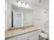Bathroom showcasing granite counters, vanity lighting, a large mirror and a shower-tub combo at 11847 Rizvan Pl, Covington, GA 30014