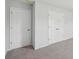 Bedroom featuring neutral carpet, light grey paint, one standard door and a closet with bi-fold doors at 11847 Rizvan Pl, Covington, GA 30014
