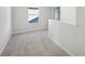 Open hallway with neutral carpet, light grey paint and a view of the blue house outside the window at 11847 Rizvan Pl, Covington, GA 30014