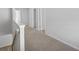 Upstairs hallway with neutral color palette and carpet at 11847 Rizvan Pl, Covington, GA 30014
