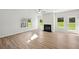 Bright living room featuring wood-look floors, a ceiling fan, black fireplace, and a door to the outside at 11847 Rizvan Pl, Covington, GA 30014