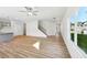Living room featuring wood-look floors, ceiling fan, a staircase, and lots of natural light at 11847 Rizvan Pl, Covington, GA 30014