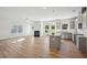 Open concept living, dining, and kitchen area with wood-look floors, fireplace, and stainless steel appliances at 11847 Rizvan Pl, Covington, GA 30014