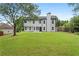 Large backyard featuring green grass, trees, and the back of the house at 160 Magnolia Walk Ln, South Fulton, GA 30349