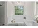 Spa-like bathroom featuring a soaking tub with hexagon tiling and gold fixtures at 160 Magnolia Walk Ln, South Fulton, GA 30349