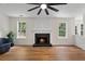 Bright living room with a fireplace, fan, luxury vinyl floors, and bright windows for natural light at 160 Magnolia Walk Ln, South Fulton, GA 30349