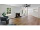 Open living room features a fireplace, vinyl floors, fan, and bright windows for natural lighting at 160 Magnolia Walk Ln, South Fulton, GA 30349