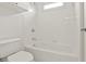 All-white bathroom featuring a tiled shower and tub combination with a window bringing in natural light at 1701 Tipton Nw Ct, Acworth, GA 30101