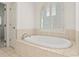 Bright, tiled bathroom features large bathtub and a window with shutters for natural light and privacy at 1701 Tipton Nw Ct, Acworth, GA 30101