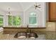 Kitchen sink with granite countertop, tile backsplash, and view to the backyard at 1701 Tipton Nw Ct, Acworth, GA 30101