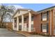 Angle shot of a brick apartment with white columns and black shutters, set in a quiet, tree-lined neighborhood at 135 E Hill St # 24, Decatur, GA 30030