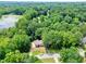 Overhead shot showing a lovely home nestled in a serene, wooded area near a lake at 400 Hunt River Way, Suwanee, GA 30024