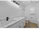 Bathroom features a white vanity with quartz countertops, black hardware and light fixture, and wood grain floors at 400 Hunt River Way, Suwanee, GA 30024