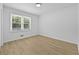 Empty bedroom with natural light has wood grain floors and white walls at 400 Hunt River Way, Suwanee, GA 30024