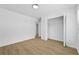 Empty bedroom features wood grain floors, a window, and a closet at 400 Hunt River Way, Suwanee, GA 30024