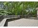 Wood deck overlooking a wooded back yard featuring a built in bench at 400 Hunt River Way, Suwanee, GA 30024