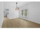 Open dining room area with modern light fixture and luxury vinyl flooring at 400 Hunt River Way, Suwanee, GA 30024