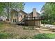 Exterior back view of a tan home featuring a wood deck and walkout basement at 400 Hunt River Way, Suwanee, GA 30024