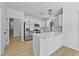 This kitchen has white cabinets, stainless steel appliances, an island with quartz countertops, and wood grain floors at 400 Hunt River Way, Suwanee, GA 30024
