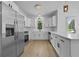 Modern kitchen features white cabinets, stainless steel appliances, quartz countertops, and wood grain floors at 400 Hunt River Way, Suwanee, GA 30024