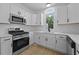Modern kitchen features white cabinets, stainless steel appliances, quartz countertops, and subway tile backsplash at 400 Hunt River Way, Suwanee, GA 30024