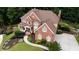 Aerial view of a stately brick home boasting lush landscaping, mature trees, and a private driveway at 200 Long Needle Ct, Sugar Hill, GA 30518