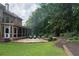 Expansive backyard showcasing a large patio, lush lawn, and mature trees providing shade at 200 Long Needle Ct, Sugar Hill, GA 30518
