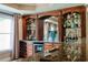 Custom bar area with ample storage, wine rack, glass shelving, and granite countertop at 200 Long Needle Ct, Sugar Hill, GA 30518